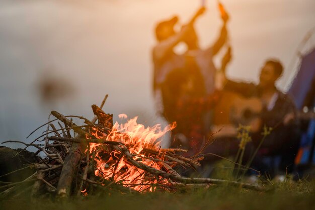 Foto gruppe von freunden, die campen. sie sitzen um das feuerlager.