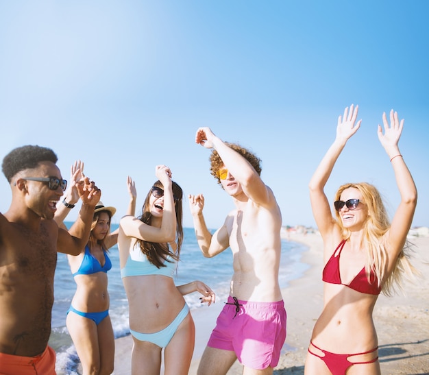 Gruppe von Freunden, die Disco-Musik am Strand tanzen