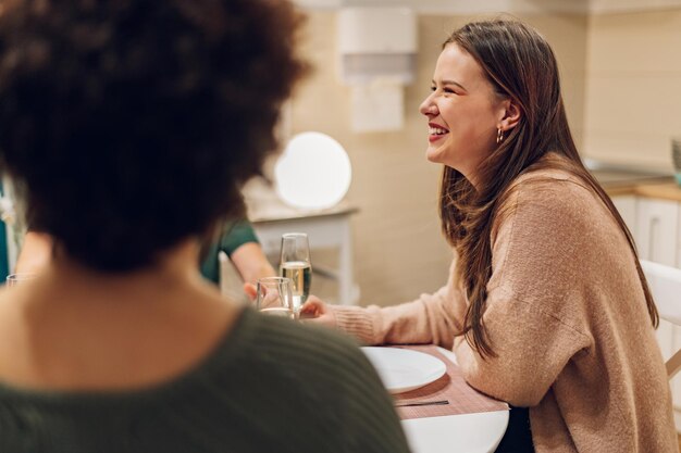 Gruppe von Freunden, die gemeinsam am Küchentisch zu Abend essen