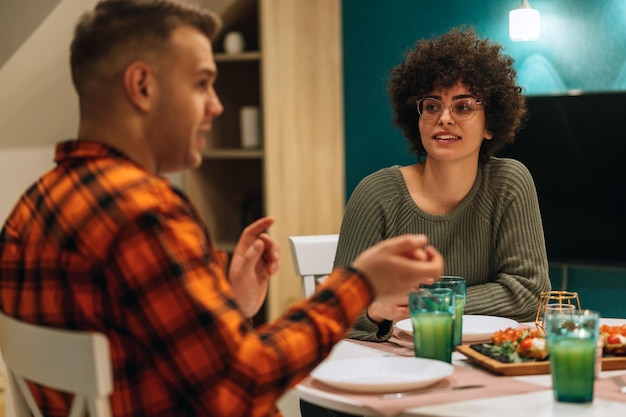 Foto gruppe von freunden, die gemeinsam am küchentisch zu abend essen