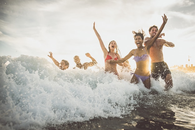 Gruppe von Freunden, die große Party und Spiele am Strand machen