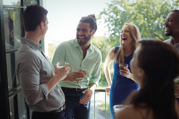 Gruppe von Freunden, die miteinander interagieren, während sie einen Cocktail trinken