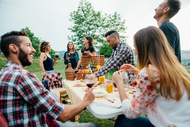 Gruppe von Freunden, die Zeit damit verbringen, ein Picknick und einen Grill zu machen