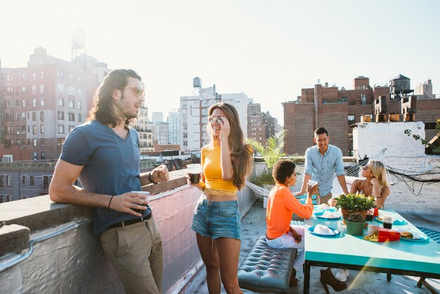 Gruppe von Freunden, die Zeit zusammen auf einem Dach in New York City verbringen, Lifestyle-Konzept mit glücklichen Menschen