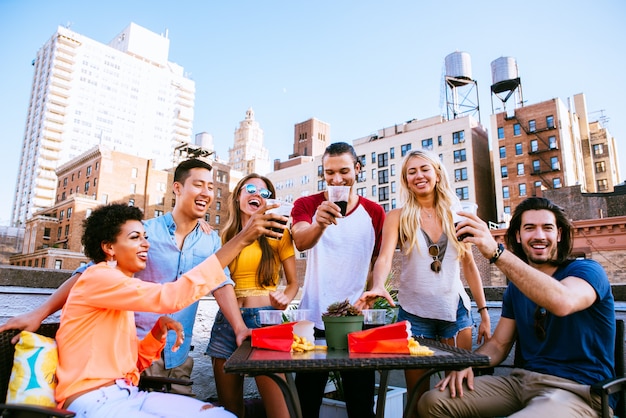 Gruppe von Freunden, die Zeit zusammen auf einem Dach in New York City verbringen, Lifestyle-Konzept mit glücklichen Menschen