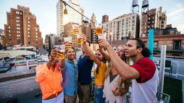 Gruppe von Freunden, die Zeit zusammen auf einem Dach in New York City verbringen, Lifestyle-Konzept mit glücklichen Menschen