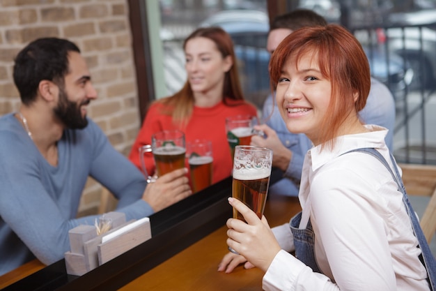 Gruppe von Freunden, die zusammen Bier in der Kneipe trinken