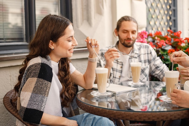 Gruppe von Freunden, die zusammen einen Kaffee in einem Café im Freien trinken