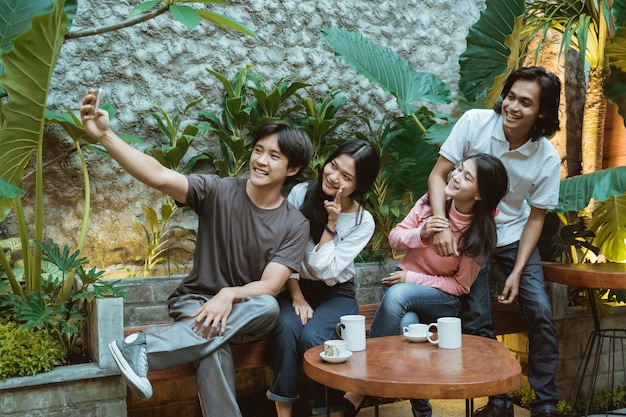 Gruppe von Freunden im Café, die zusammen ein Selfie machen