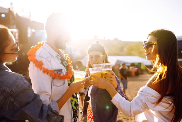 Gruppe von Freunden mit Biertanzen und Spaß beim Musikfestival zusammenCelebration Konzept