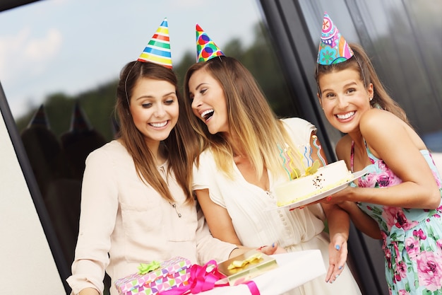 Gruppe von Freunden mit Kuchen und Geschenken, die Geburtstag feiern