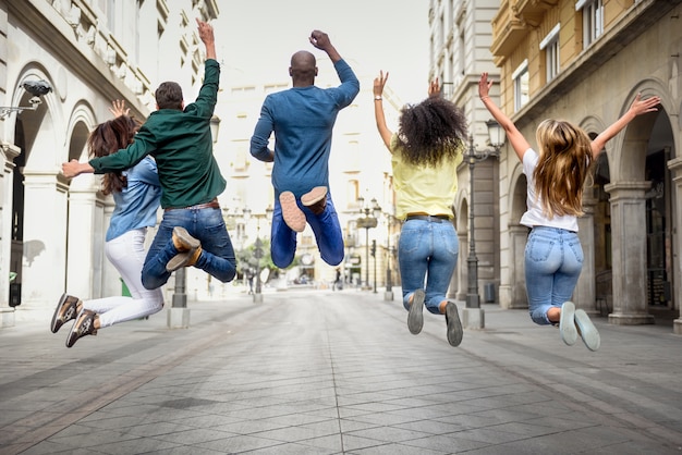 Gruppe von Freunden springen zusammen im Freien