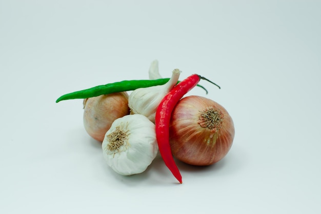 Gruppe von frischen Knoblauchzwiebeln rote und grüne Chilis auf weißem Hintergrund