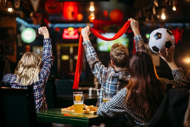 Gruppe von Fußballfans, die Spiel in der Sportbar beobachten