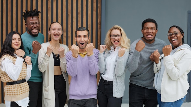 Gruppe von Geschäftsangestellten lächelnd glücklich stehend mit Fäusten im Büro
