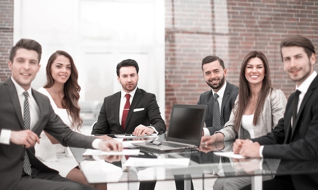 Gruppe von Geschäftsleuten, die am Bürotisch sitzen