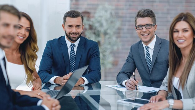 Gruppe von Geschäftsleuten, die am Deskthe-Konzept der Teamarbeit sitzen