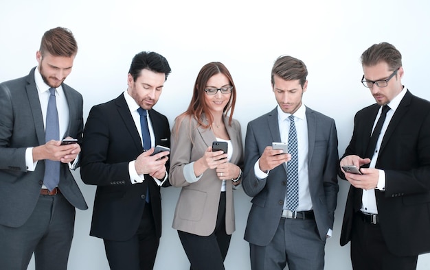 Gruppe von Geschäftsleuten, die auf die Bildschirme ihrer Smartphones und ihrer Technologie schauen