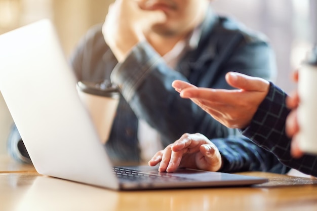 Gruppe von Geschäftsleuten, die einen Laptop für die Präsentation in einem Meeting verwenden und verwenden