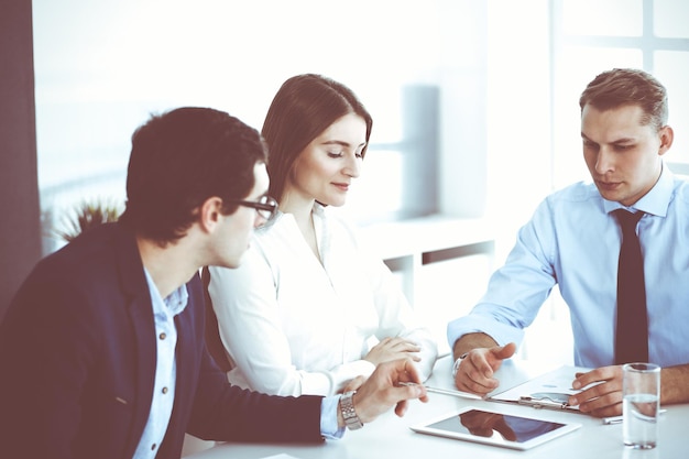 Gruppe von Geschäftsleuten, die Fragen bei einem Treffen in einem modernen Büro diskutieren. Manager bei Verhandlungen oder Brainstorming. Teamwork, Partnerschaft und Geschäftskonzept