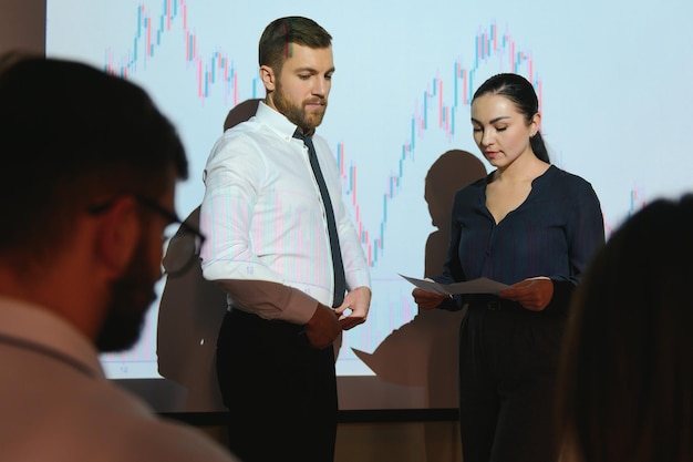 Gruppe von Geschäftsleuten, die im modernen Büro arbeitenTechnisches Preisdiagramm rotes und blaues Kerzendiagramm und Computerbildschirmhintergrund für den Aktienhandel