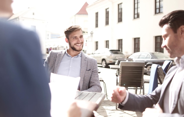 Gruppe von Geschäftsleuten, die in einem Straßencafé sitzen Konzeptfoto mit Kopierraum