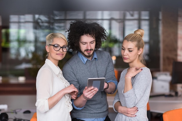 gruppe von geschäftsleuten, die sich auf das nächste treffen vorbereiten und ideen mit einem digitalen tablet diskutieren