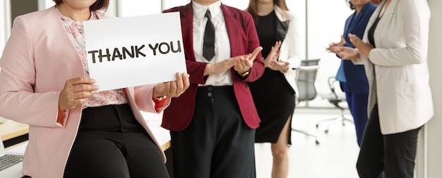 Gruppe von Geschäftsleuten schließen sich zusammen, grüßen und halten Dankeswort für Zeichen der Dankbarkeit für jemanden in einem modernen Büro. Idee für ein gutes Teamwork-Feeling und Unterstützung für Kollegen.