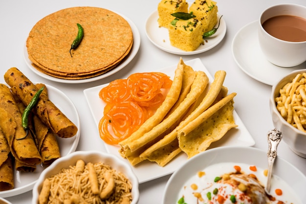 Gruppe von Gujarati-Snacks wie Jalebi-Fafda, Thepla, Khaman Dhokla, Aloo Bhujiya, Khandvi, Khakra, Dahi Vada, Gathiya mit heißem Tee