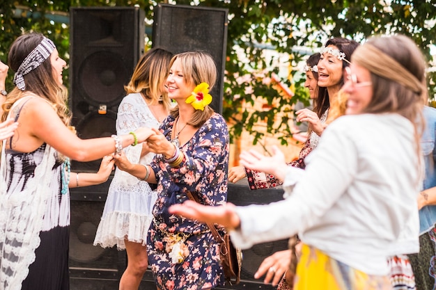 Gruppe von jungen Frauen im alternativen Stil der freien und Hippie-Rebellen, die zusammen mit Freude und Glück an einem natürlichen Ort drinnen und draußen tanzen und feiern. schöner Lebensstil für schöne Menschen