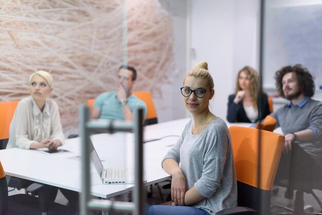 Gruppe von jungen Geschäftsleuten, die Geschäftsplan in einem modernen Start-Bürogebäude bis spät in die Nacht diskutieren