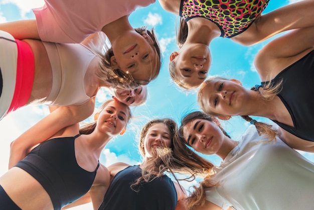 Gruppe von Kindern und jungen Mädchen mit Trainerin im Kreis als Freundschaft