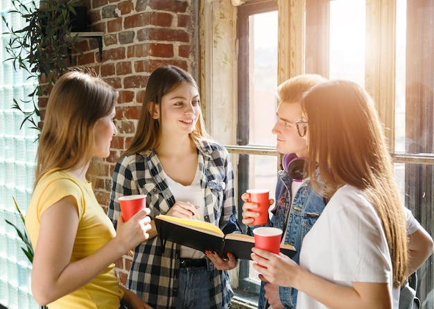 Gruppe von Klassenkameraden, die in der Pause Kaffee trinken und miteinander reden