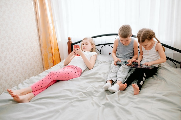 Gruppe von kleinen Kindern, die zusammen Smartphones verwenden