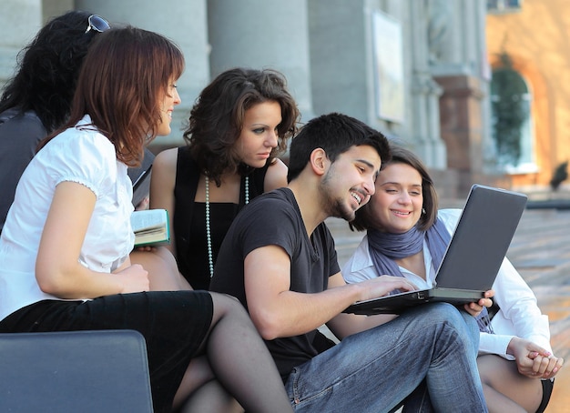 Gruppe von Kommilitonen mit Büchern und Laptop