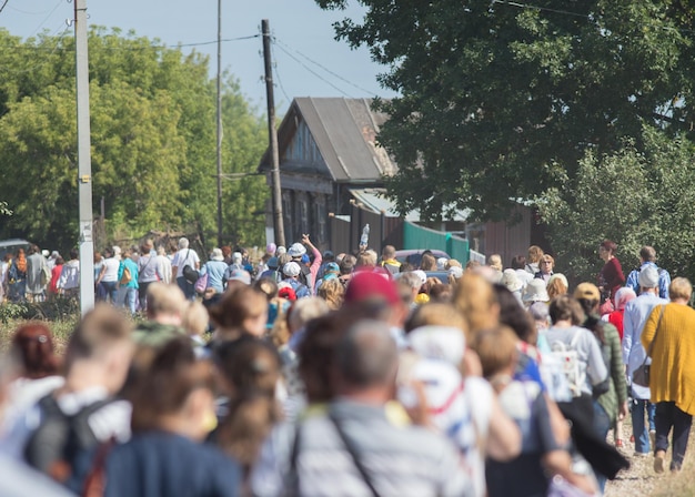 Gruppe von Leuten, die durch das Dorf gehen und die Straße hinuntergehen