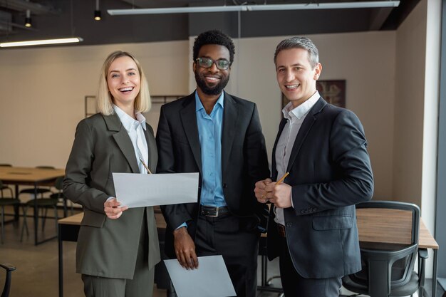 Gruppe von Leuten im Büro, die zufrieden und zuversichtlich sind