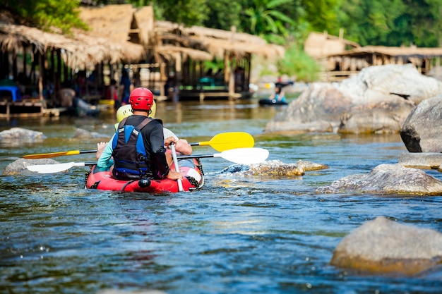 Gruppe von Leuten rafting in einem Fluss mit Führer