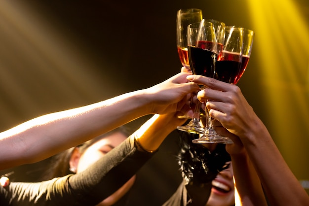 Gruppe von Leuten röstet Getränke auf der Party im Tanzclub