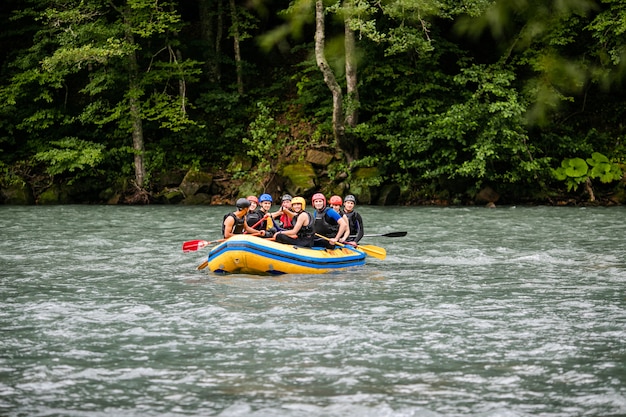 Gruppe von Männern und Frauen raften auf dem Fluss, Extremsport und Spaß