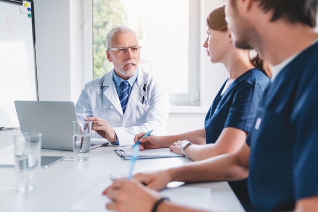 Gruppe von Medizinern während des Briefings im Sitzungssaal der Klinik