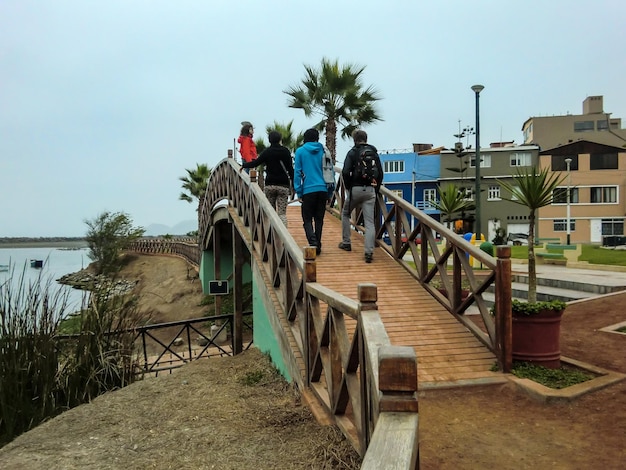 Gruppe von Menschen, die auf einer Holzbrücke spazieren gehen.