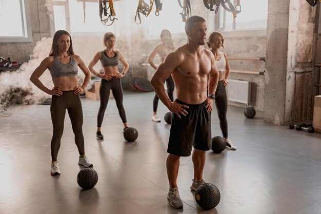 Foto gruppe von menschen, die im fitnessstudio mit ball trainieren