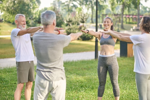 Gruppe von Menschen, die im Park Morgenübungen machen