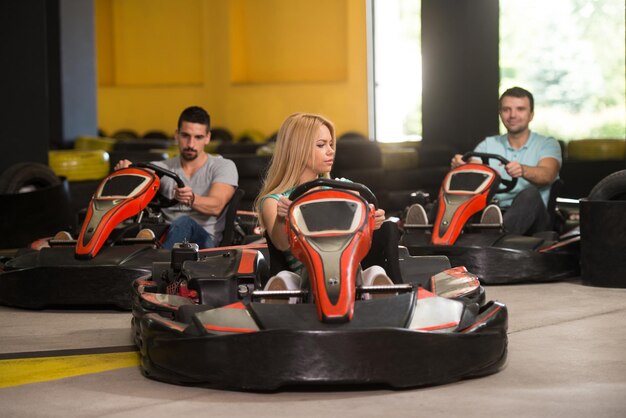 Gruppe von Menschen fährt GoKart-Auto mit Geschwindigkeit auf einem Spielplatz Rennstrecke Go-Kart ist ein beliebter Freizeitmotorsport