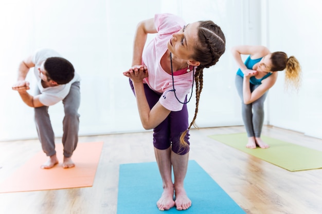 Gruppe von Menschen praktizieren Yoga zu Hause.