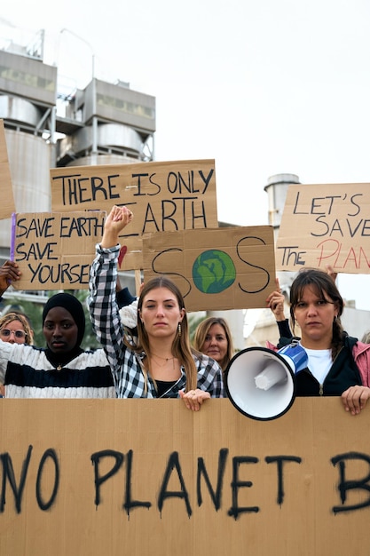 Foto gruppe von menschen verschiedener altersgruppen und nationalitäten mit erhobenen armen in protest gegen die umweltverschmutzung