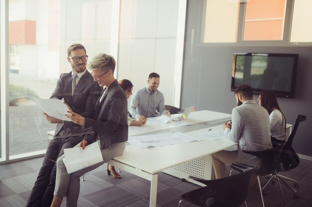 Gruppe von Mitarbeitern, die in einem modernen Büro an einem Geschäftsprojekt arbeiten