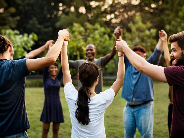 Foto gruppe von personen, die hand im park zusammenhält