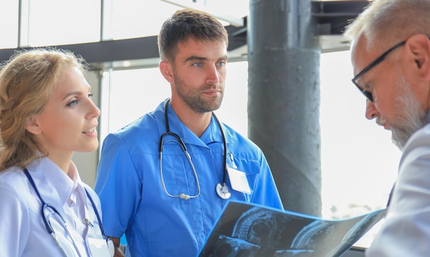 Gruppe von Ärzten, die Röntgenaufnahmen in einem Krankenhaus überprüfen